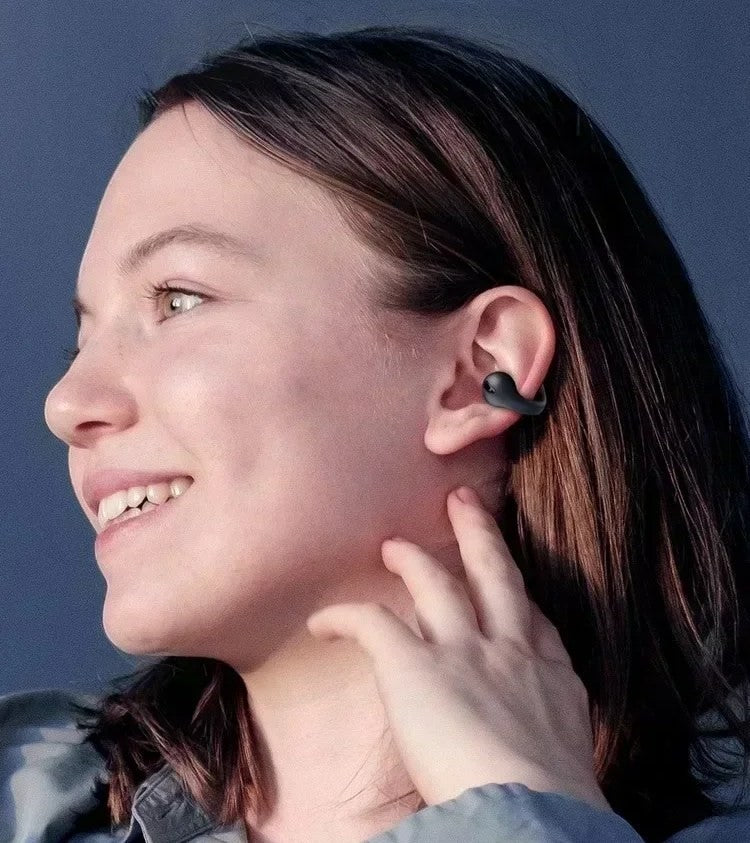Woman wearing black Evo Earbuds clip-on open-ear headphones with an earring-inspired design for all-day comfort.